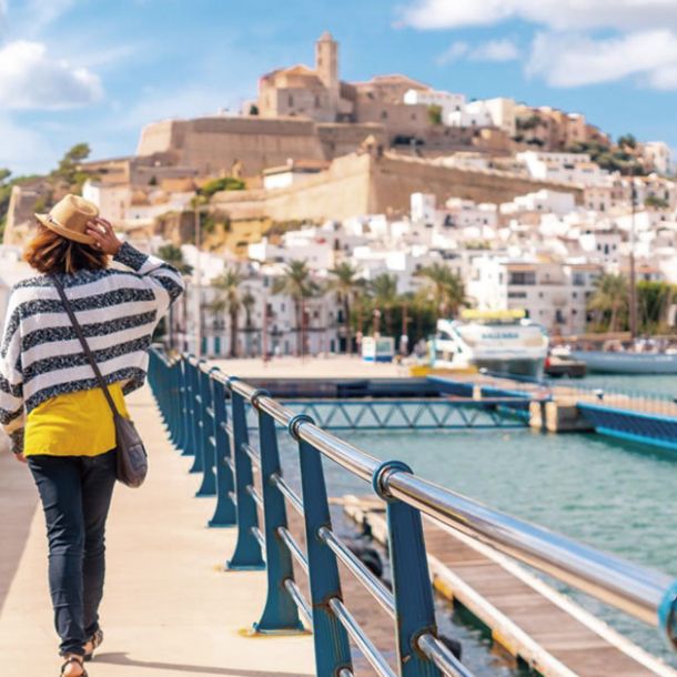 Woman strolling through Dalt Vila with Ibiza in the background